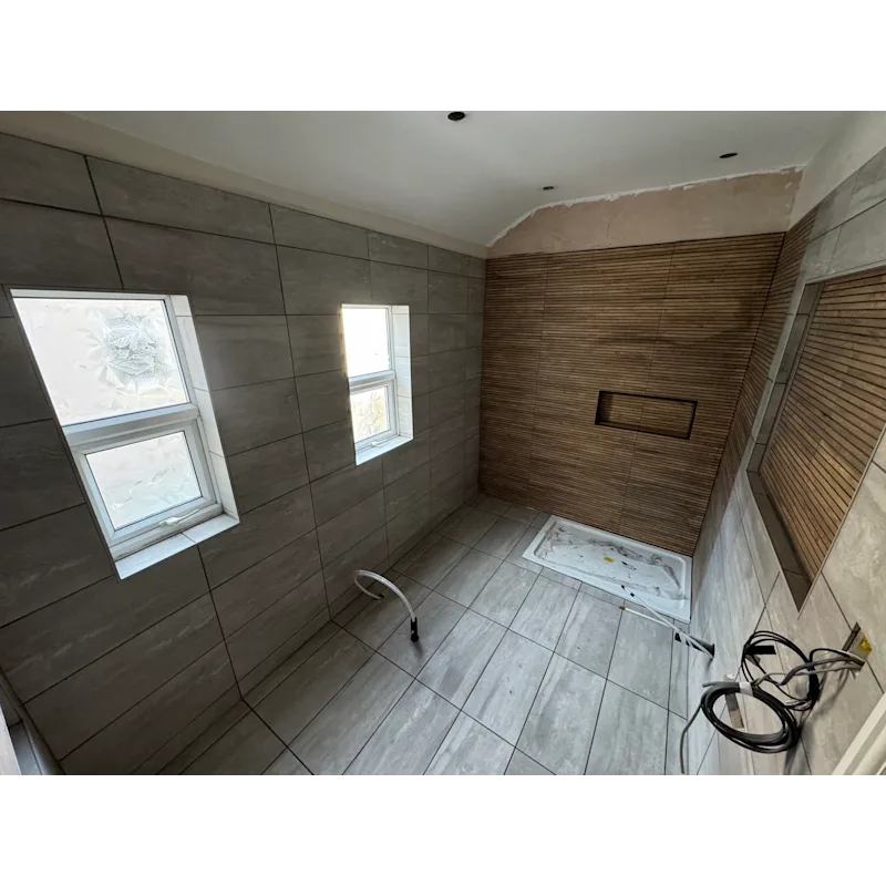 Large bathroom with grey tiles and wood-effect feature wall with niche