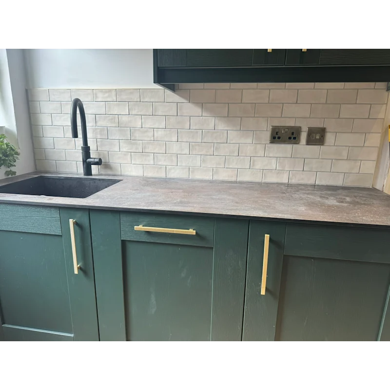 Kitchen with cream subway tile splashback and dark green cabinets