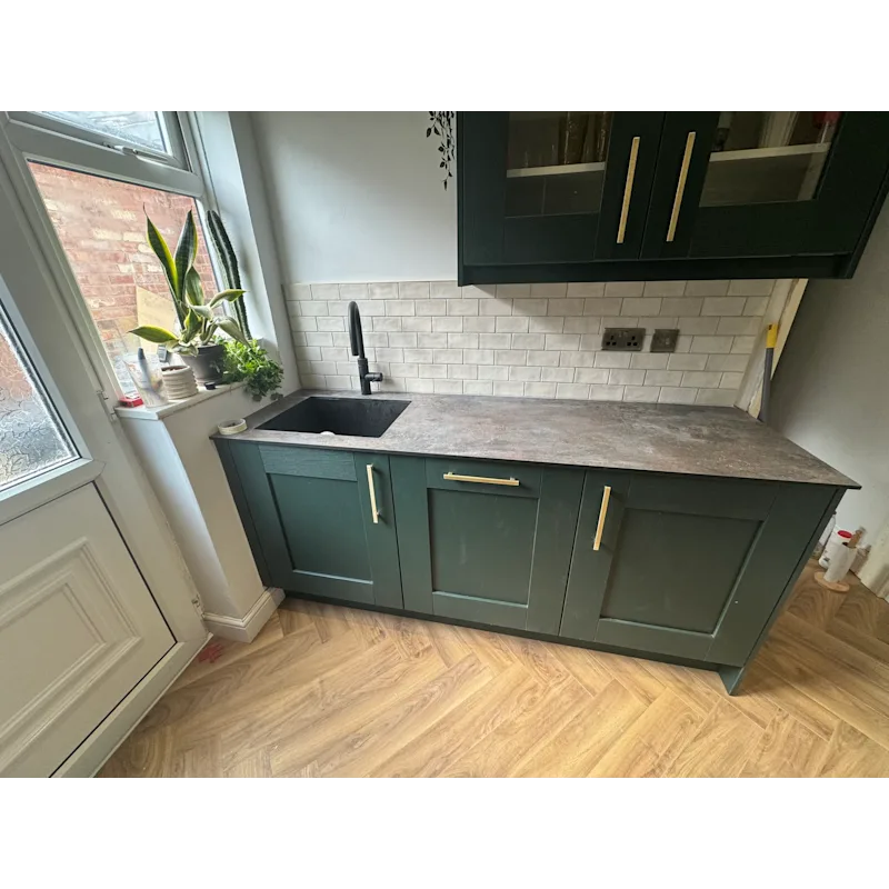 Kitchen wider view with dark green cabinets and white subway tiles