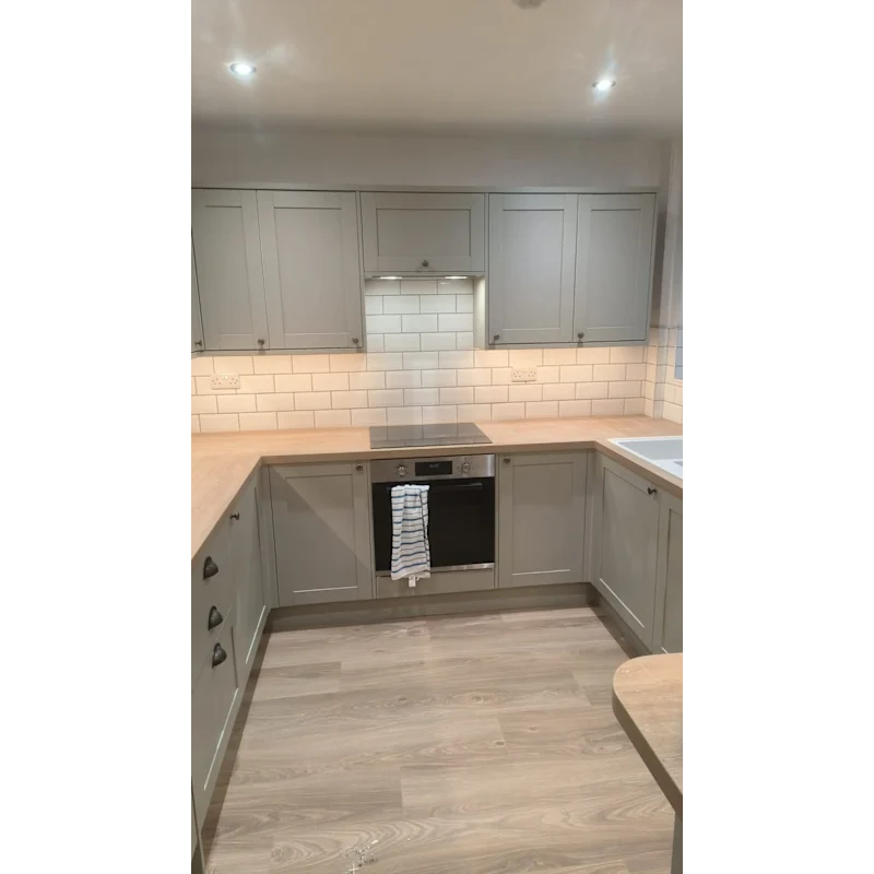 Kitchen with grey cabinets and white subway tile splashback